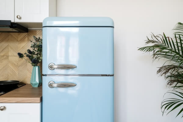 Retro blue fridge freezer Northern Ireland homeowners love, featuring stainless steel handles in a stylish modern kitchen.