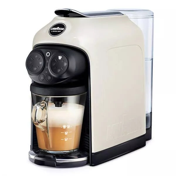 White and black coffee machine with a glass cup containing a layered drink on a white background