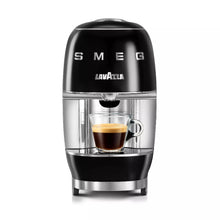 Black Smeg Lavazza coffee machine with a glass cup of espresso on a white background