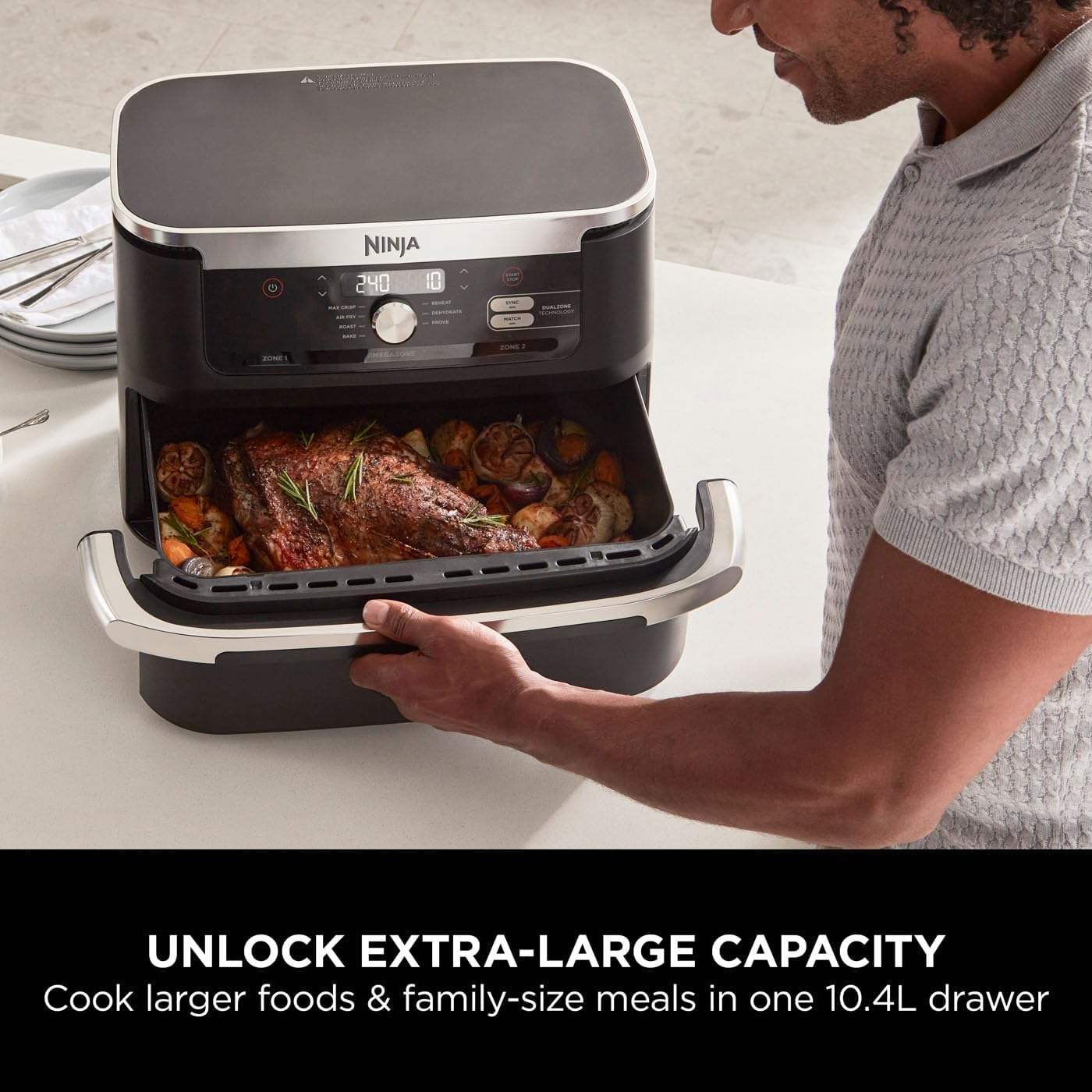 Person using a Ninja foodi appliance with roasted vegetables and text highlighting extra-large capacity.