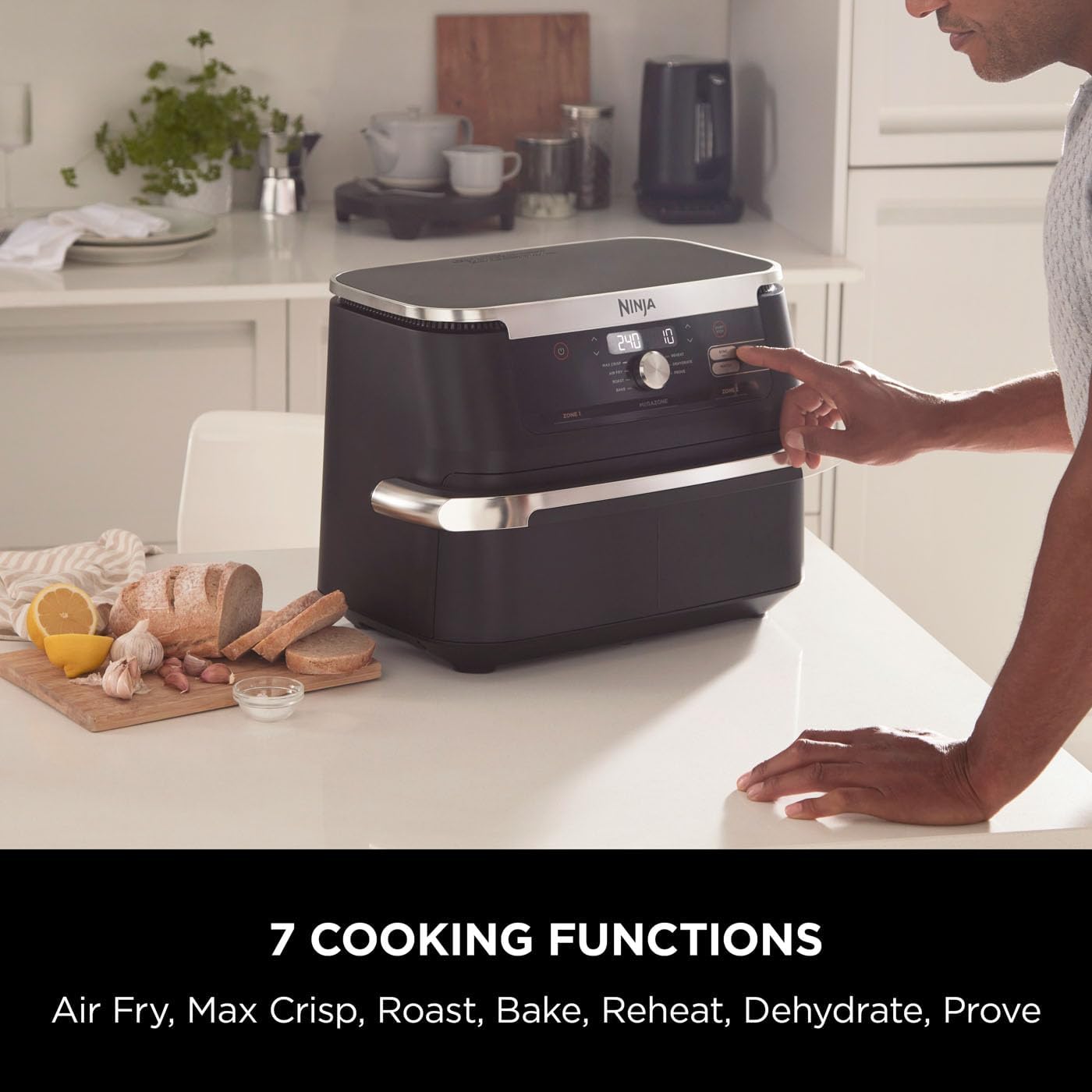 Ninja kitchen appliance on a kitchen counter with a person interacting with it, labeled '7 Cooking Functions'.
