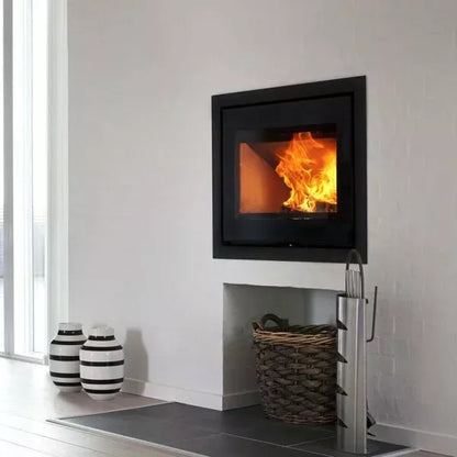 Modern wood-burning stove with flames inside, placed against a white wall.