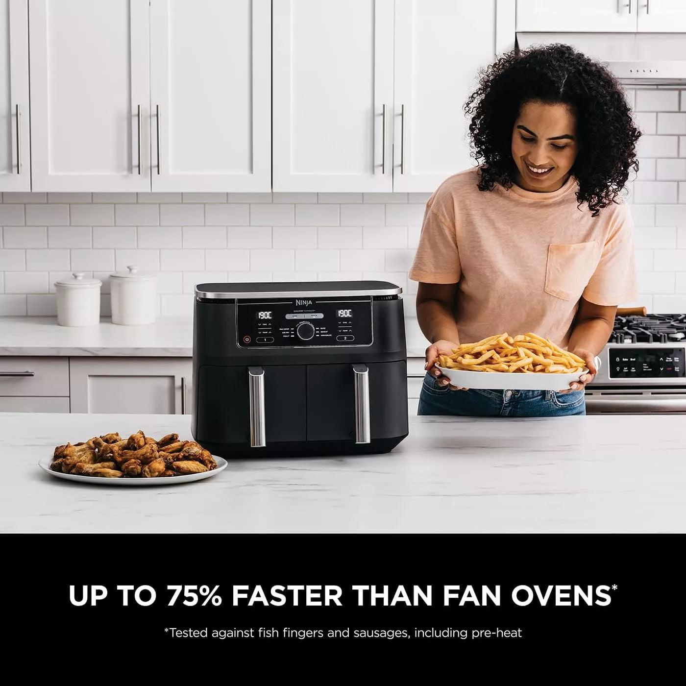 Woman in a kitchen holding a plate of food next to an air fryer with text about its speed compared to fan ovens.