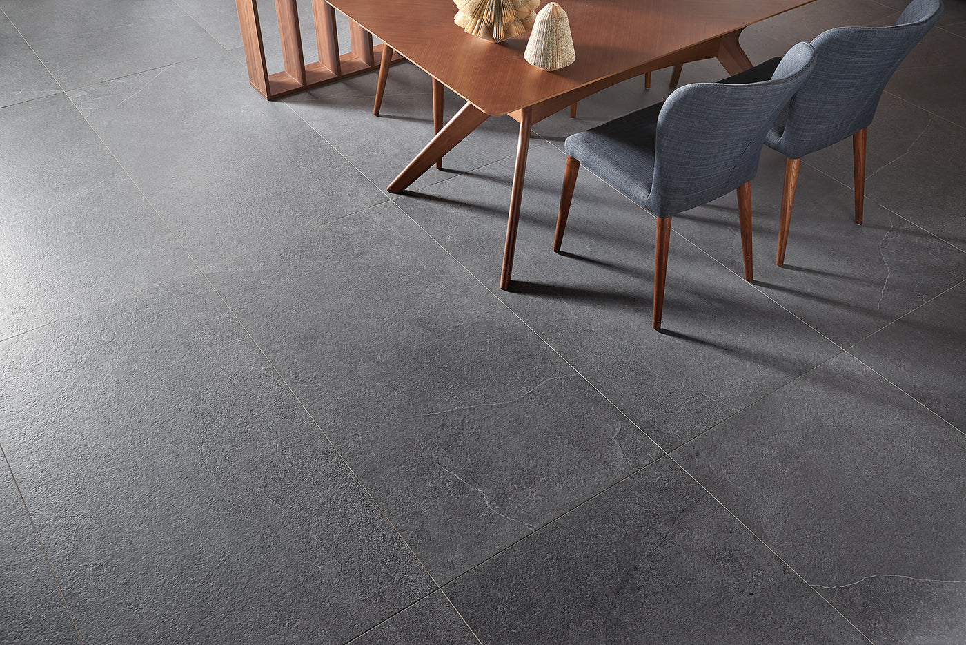 Gray tiles in a room with a wooden table and chairs.