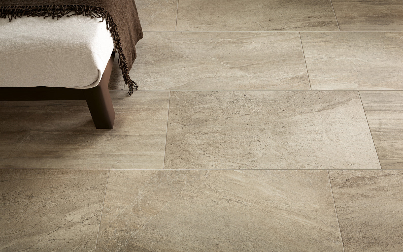 Beige tiled floor with a bed in the corner