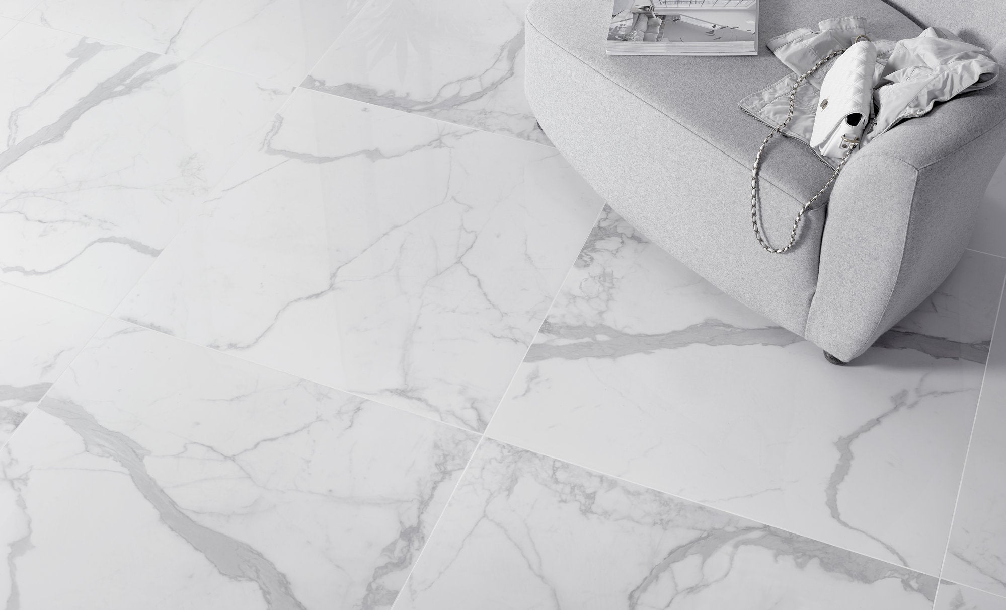 White marble-patterned floor with a gray sofa and decorative items in the background