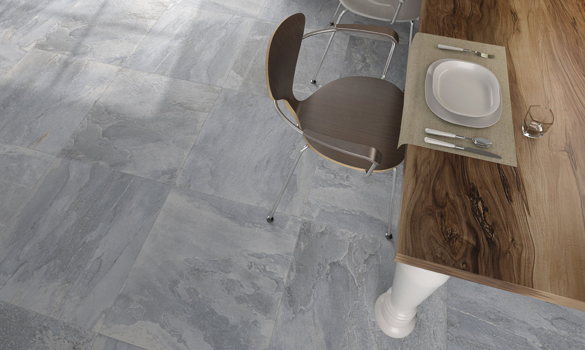 Gray tiled floor with a wooden table and chair setup.